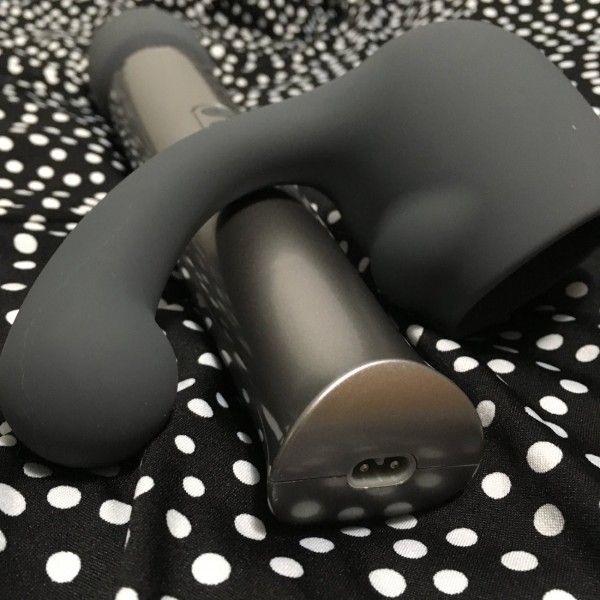 Close up of charging outlet of Le Wand and Curve attachment. Black and white polkadot fabric in background.